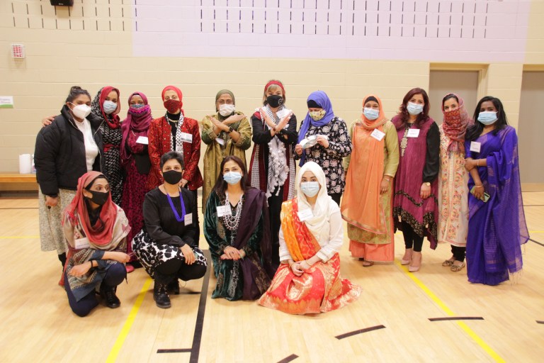 A picture of staff and volunteers posing in a school gymnasium