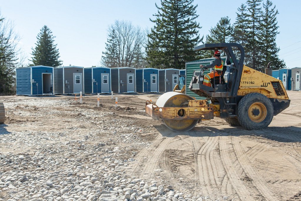 A construction machine works to prepare the Erb's Road site where 50 cabins will accommodate people experiencing unsheltered homelessness.