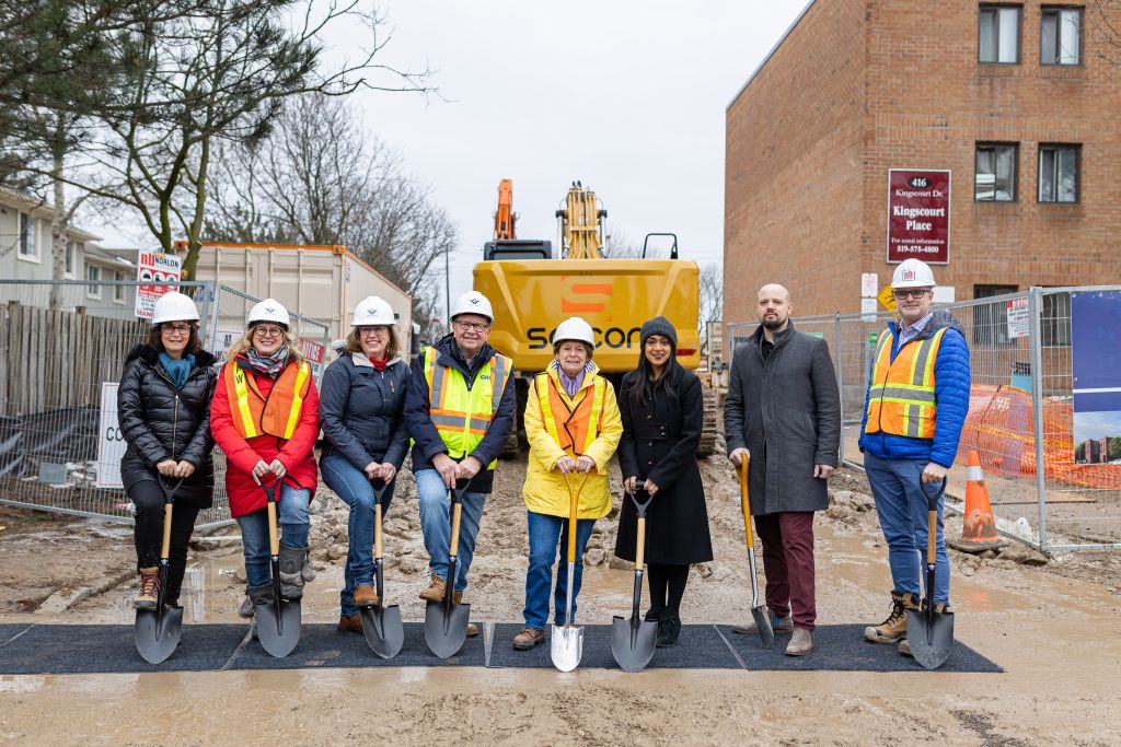 Region of Waterloo officials and other people stand with shovels and hard hats at a ground-breaking for an affordable housing project on Kingscourt Drive in Waterloo.