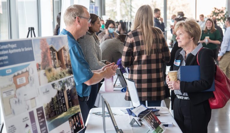 People talk at information booths for National Housing Day.
