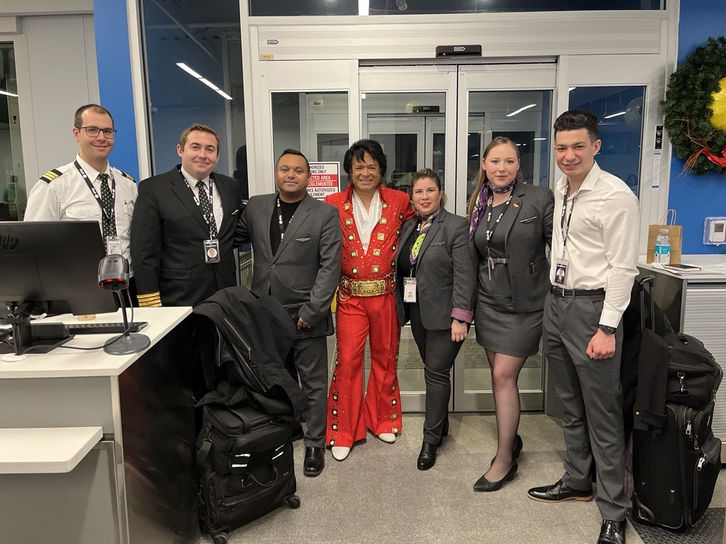 An Elvis impersonator poses with members of the Flair flight crew.
