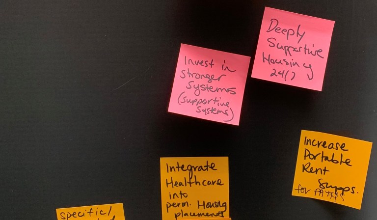 A black board with colourful sticky notes attached.