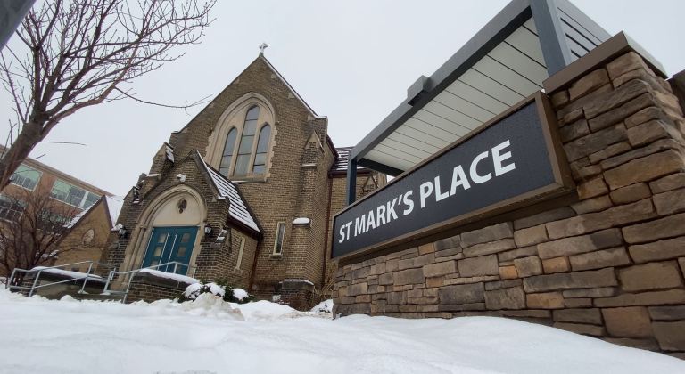 The outside of a former church in Kitchener, now renovated to become affordable housing. Sign in from that says "St. Mark's Place."