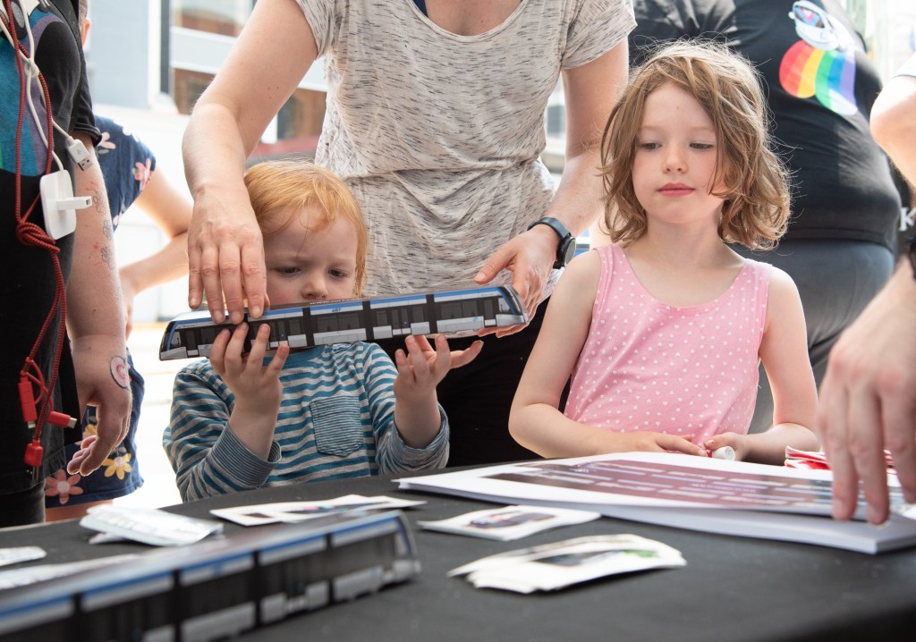 A child holds a model train at ION's 5th anniversary.