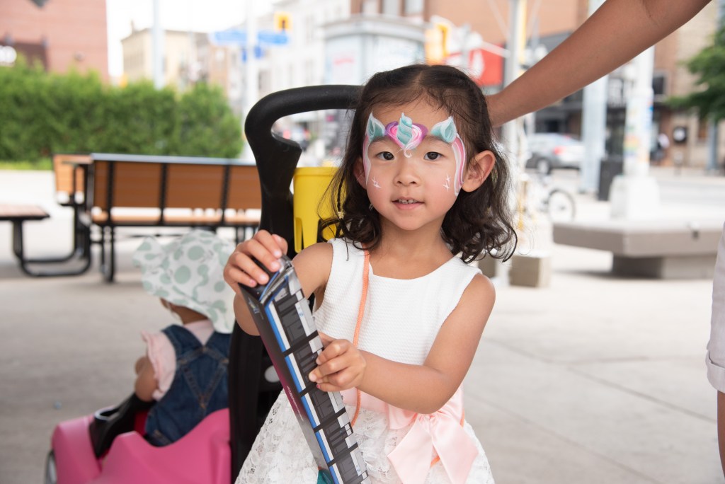 A child holds a model train at ION's 5th anniversary.