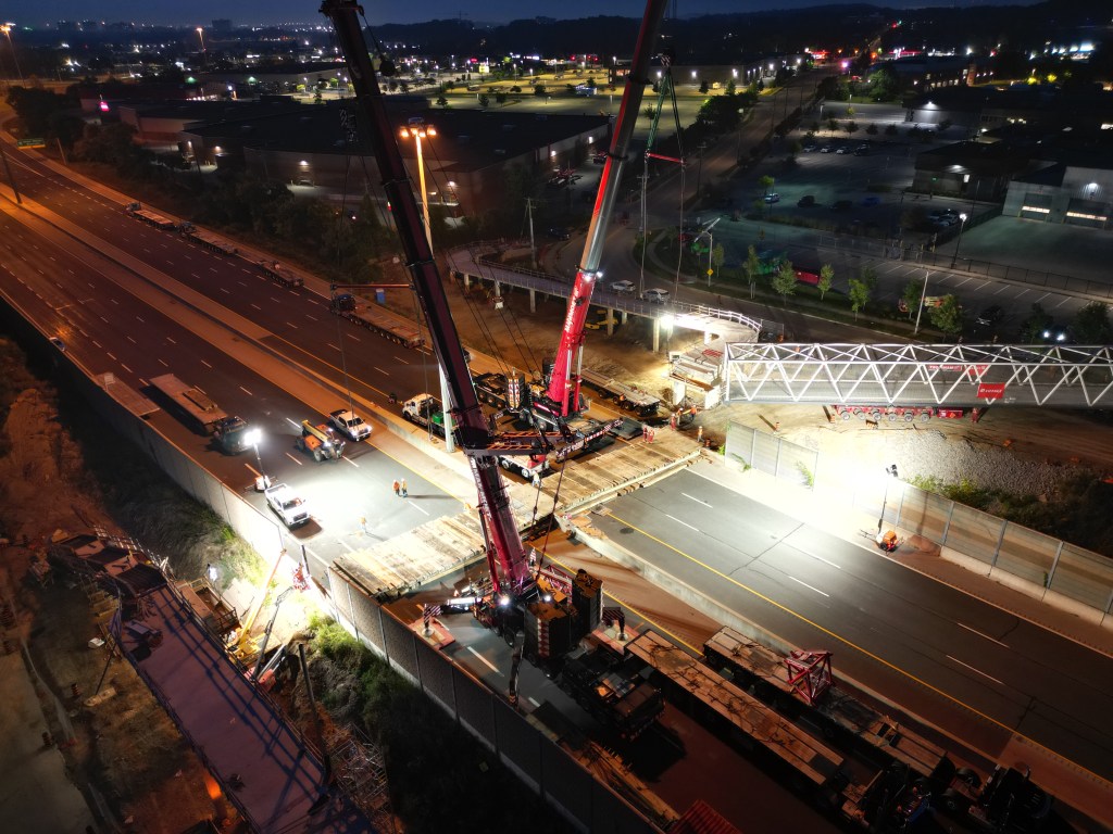 An overhead photo of a new pedestrian bridge installed over Highway 7/8 in Kitchener at night.