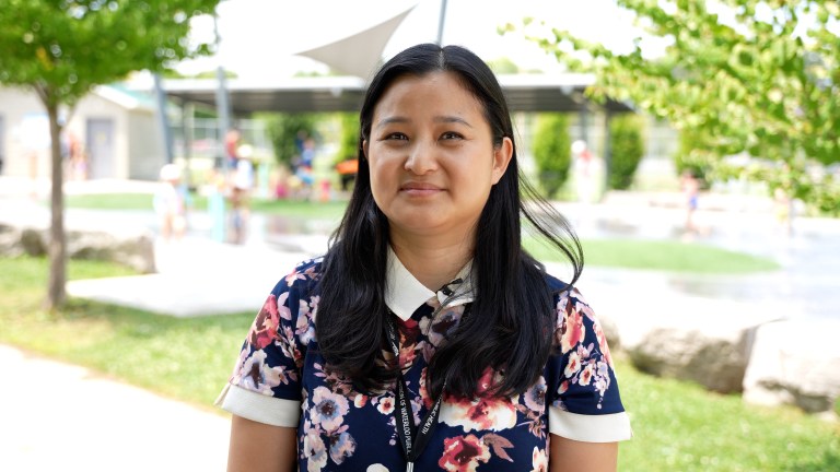 A woman stands looking at the camera for an interview.