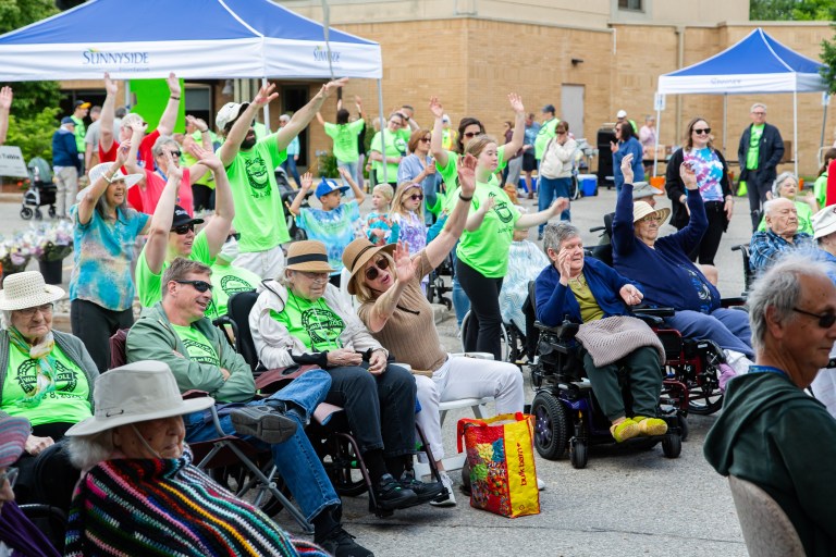 People in green t-shirts at a Walk and Roll fundraiser.