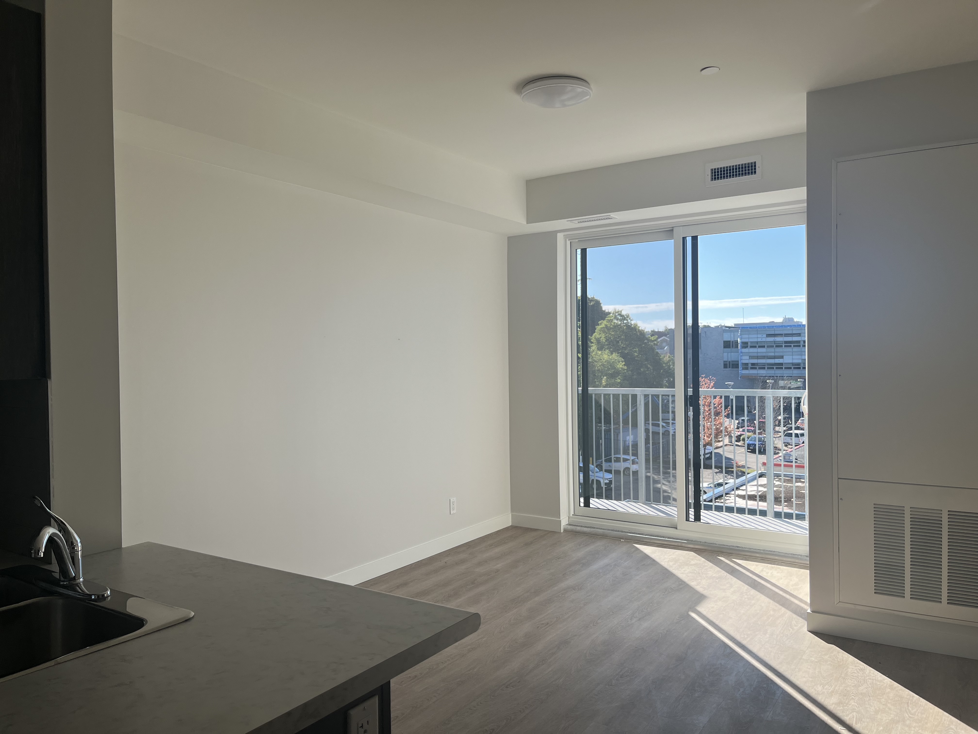 Inside a brightly-lit, unfurnished apartment.
