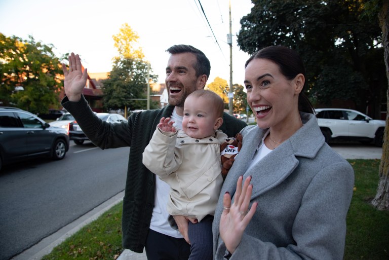 The Whiteside family stands by the side of a road to wave at a GRT bus.