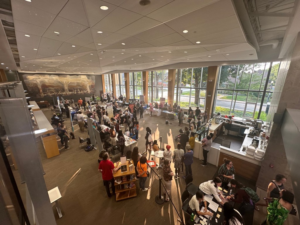 Overhead view of a crowd of people at the the “Newcomer Information Night: Health and Wellbeing Fair.”