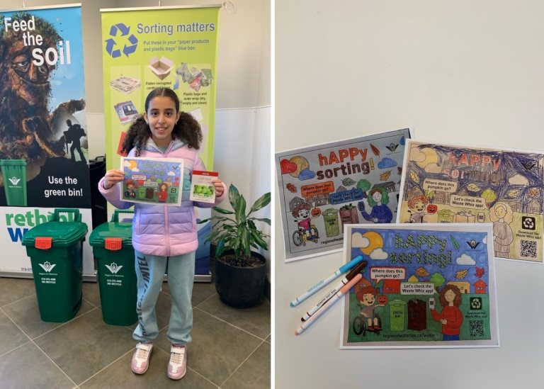 A child holding a colouring page, standing in front of green bins.