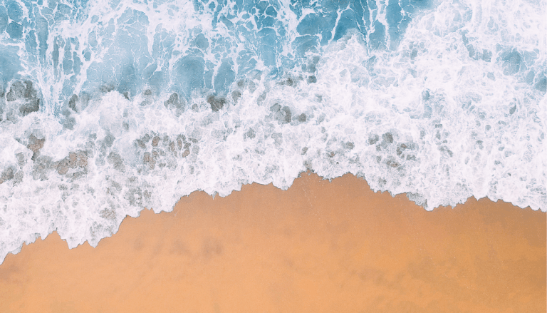Foamy waves wash up on a tropical beach.