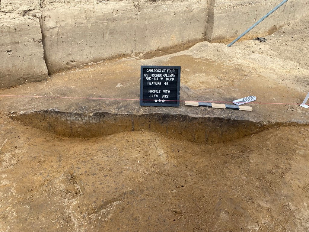 A black sign marks some archaeological work.