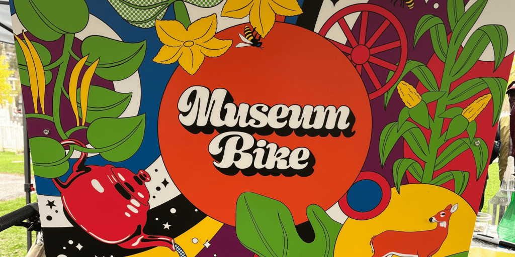 A colourful art design with the words "Museum Bike" on a red circle, surrounded by plants and other drawings.