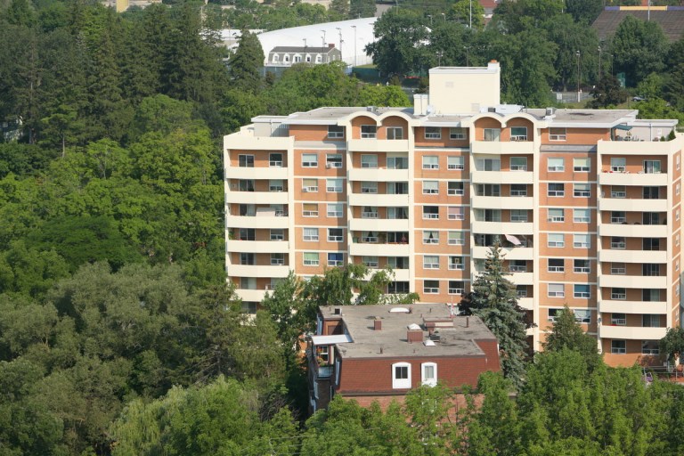 Aerial photo of a large apartment building surrounded by trees.
