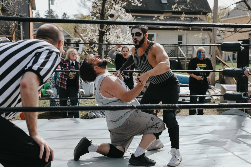 Two wrestlers fight in a backyard wrestling ring. 